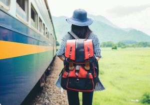 Persona con mochila al lado de un tren